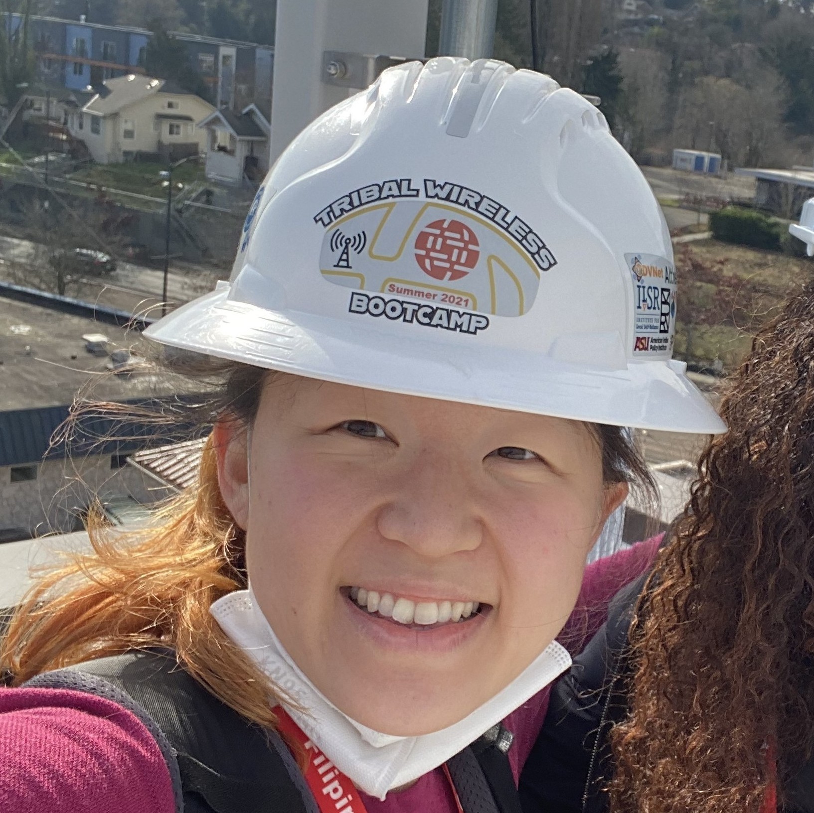 Esther Jang standing on the roof of the Filipino Community Center wearing a hard hat